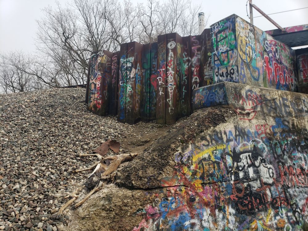 A train trestle covered in graffiti.